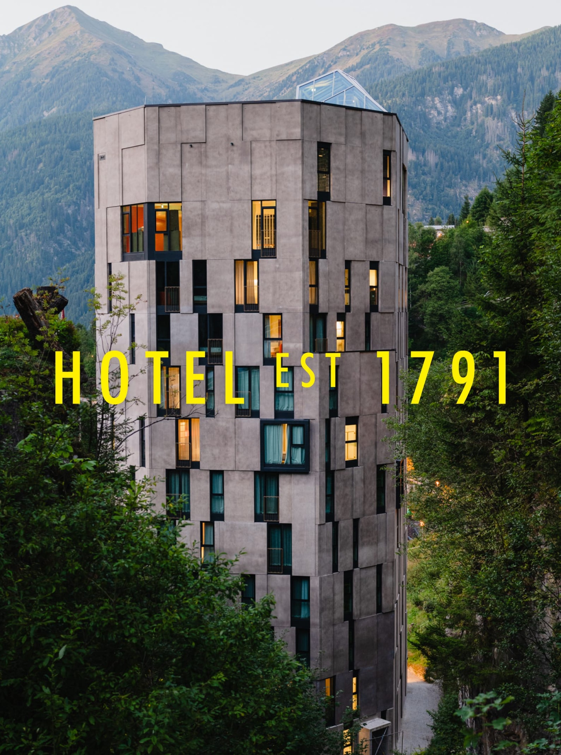 Ein großes Hotelgebäude mit dem Text "HOTEL EST 1791" vor Bergen und Bäumen.