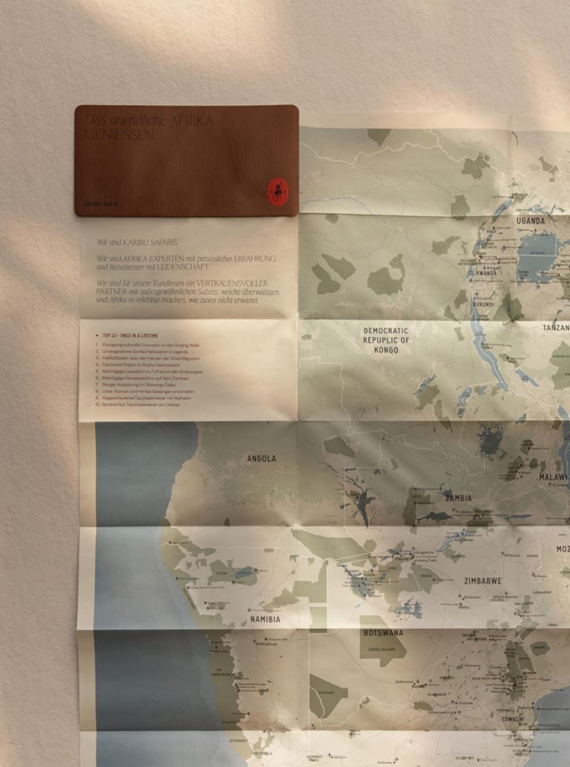 Eine Karte von Afrika mit Text über Karibu Safaris, die Touren nach Angola, Uganda und Botswana anbietet.