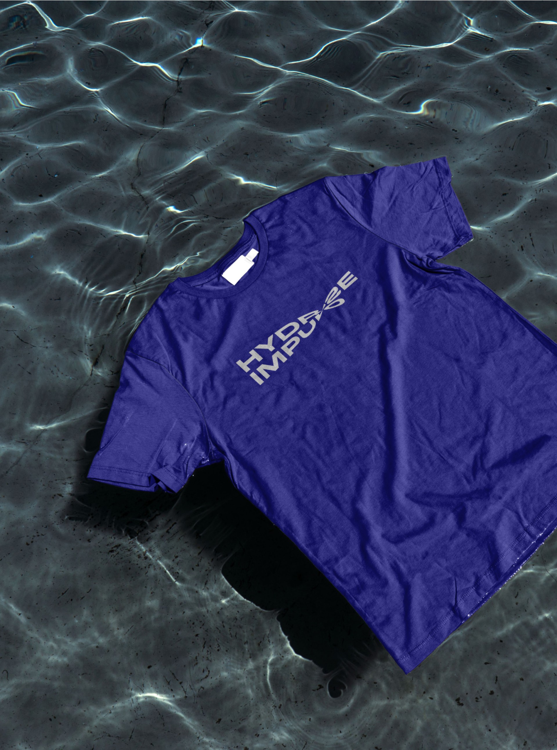 Ein violettes "Hydrate Impulse" T-Shirt liegt in leicht bewegtem Wasser. Das Shirt ist teilweise nass.