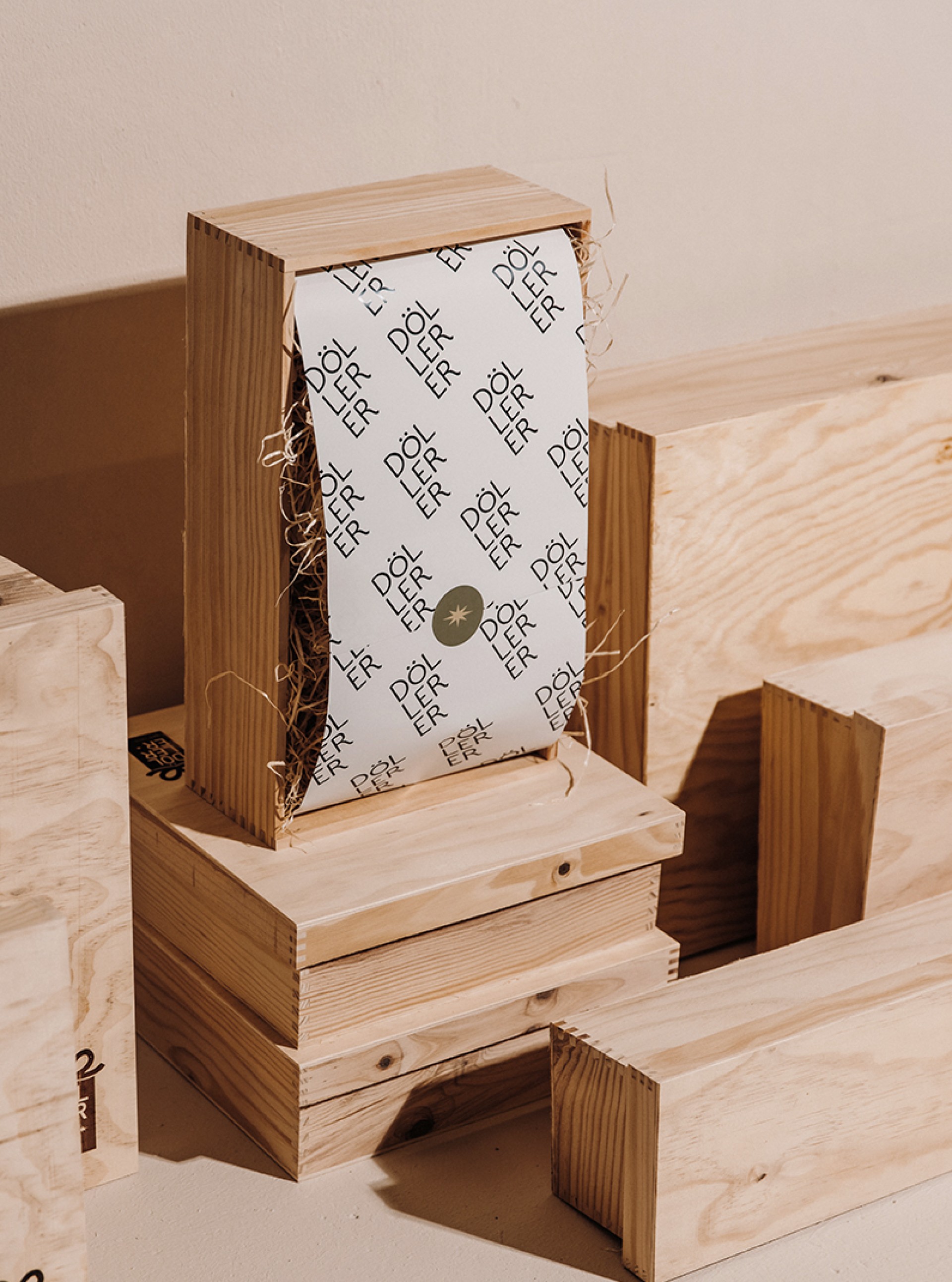 Eine Holzkiste mit Papier mit dem Text "DÖLLER" in wiederholten Mustern.