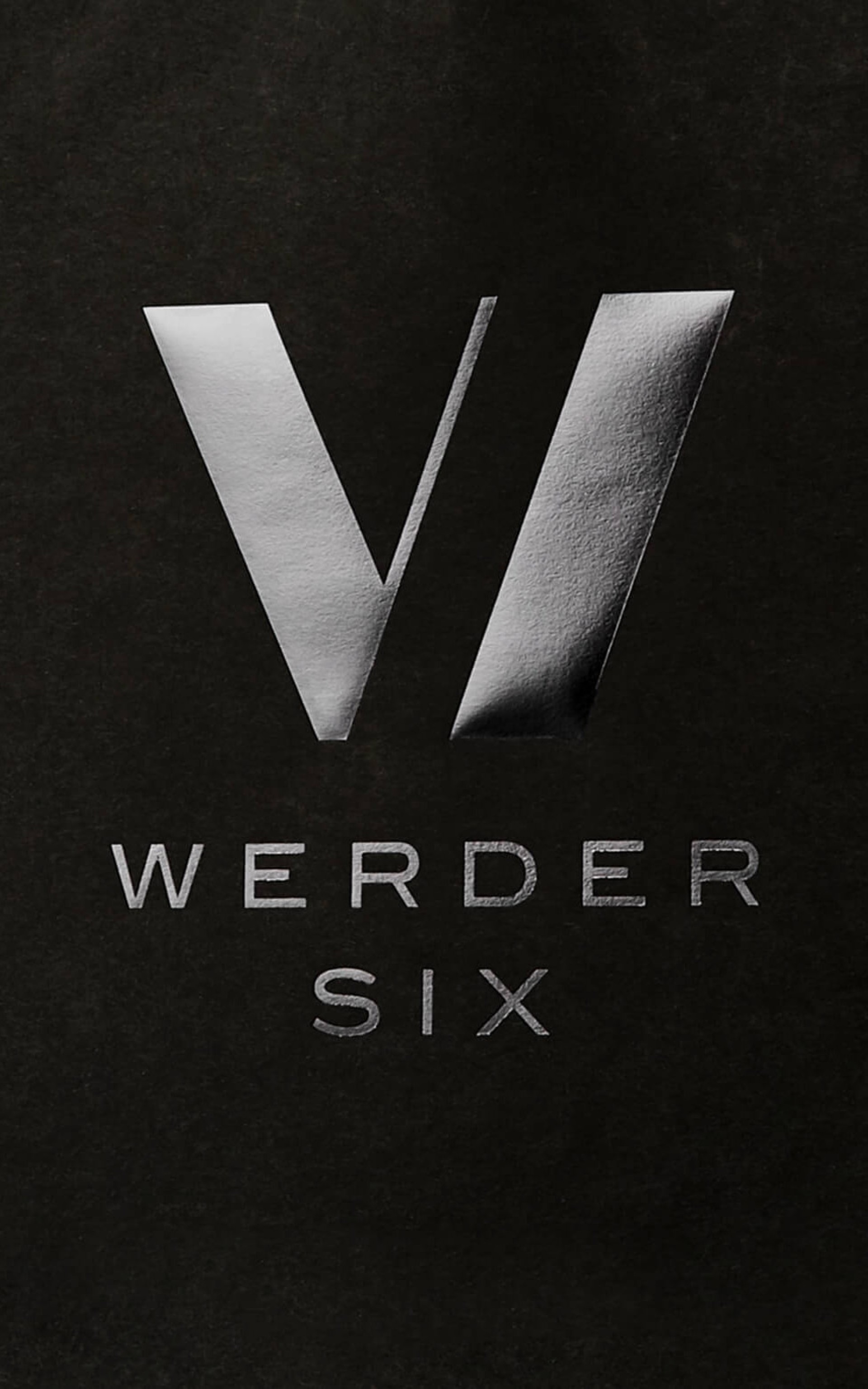 Ein graues „VI“-Logo über dem Text „WERDER SIX“ auf schwarzem Hintergrund.