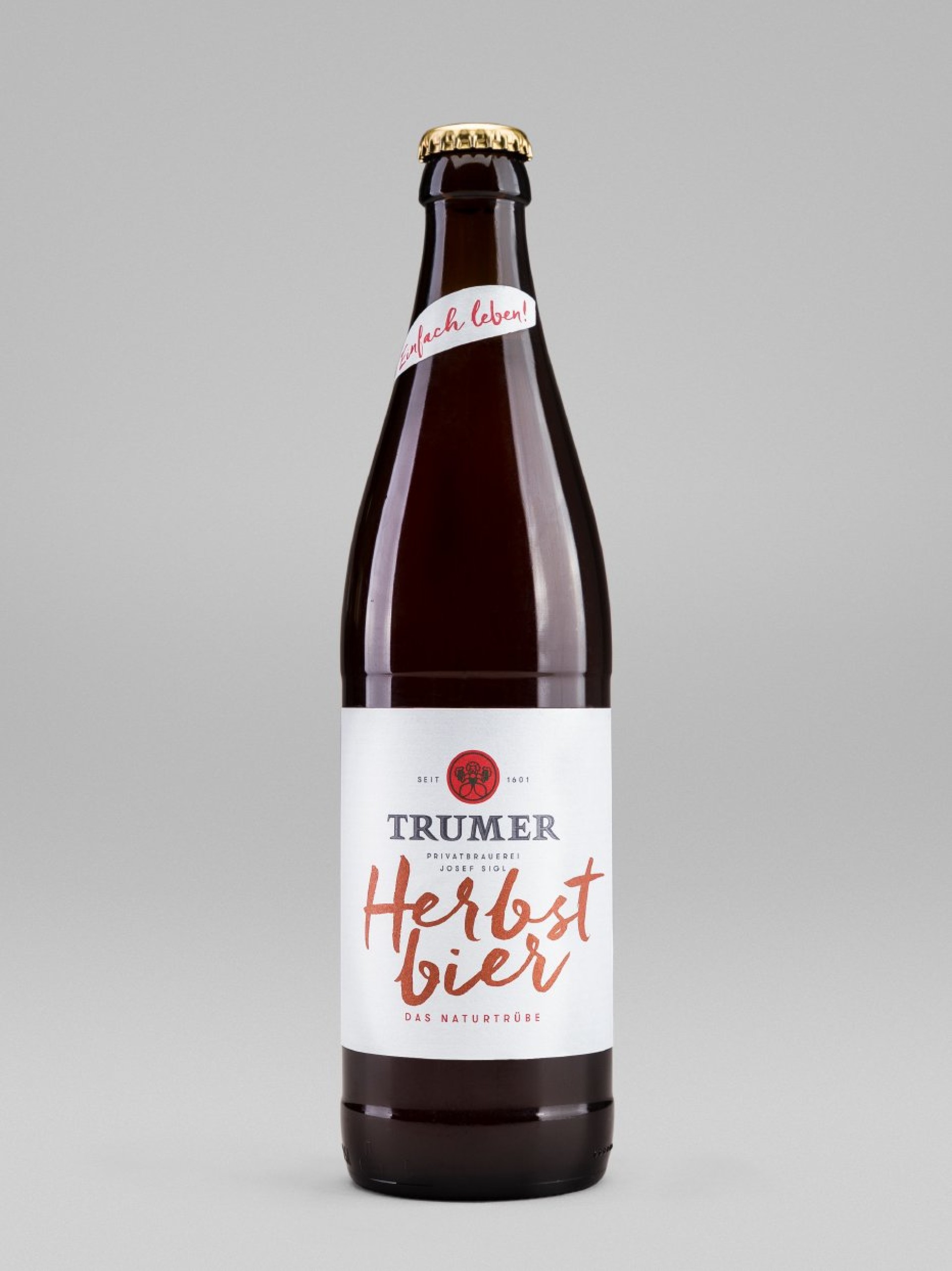 Braune "Trumer Herbstbier"-Flasche mit goldenem Deckel. Aufschrift "einfach leben!" und Etikett "Das naturtrübe".