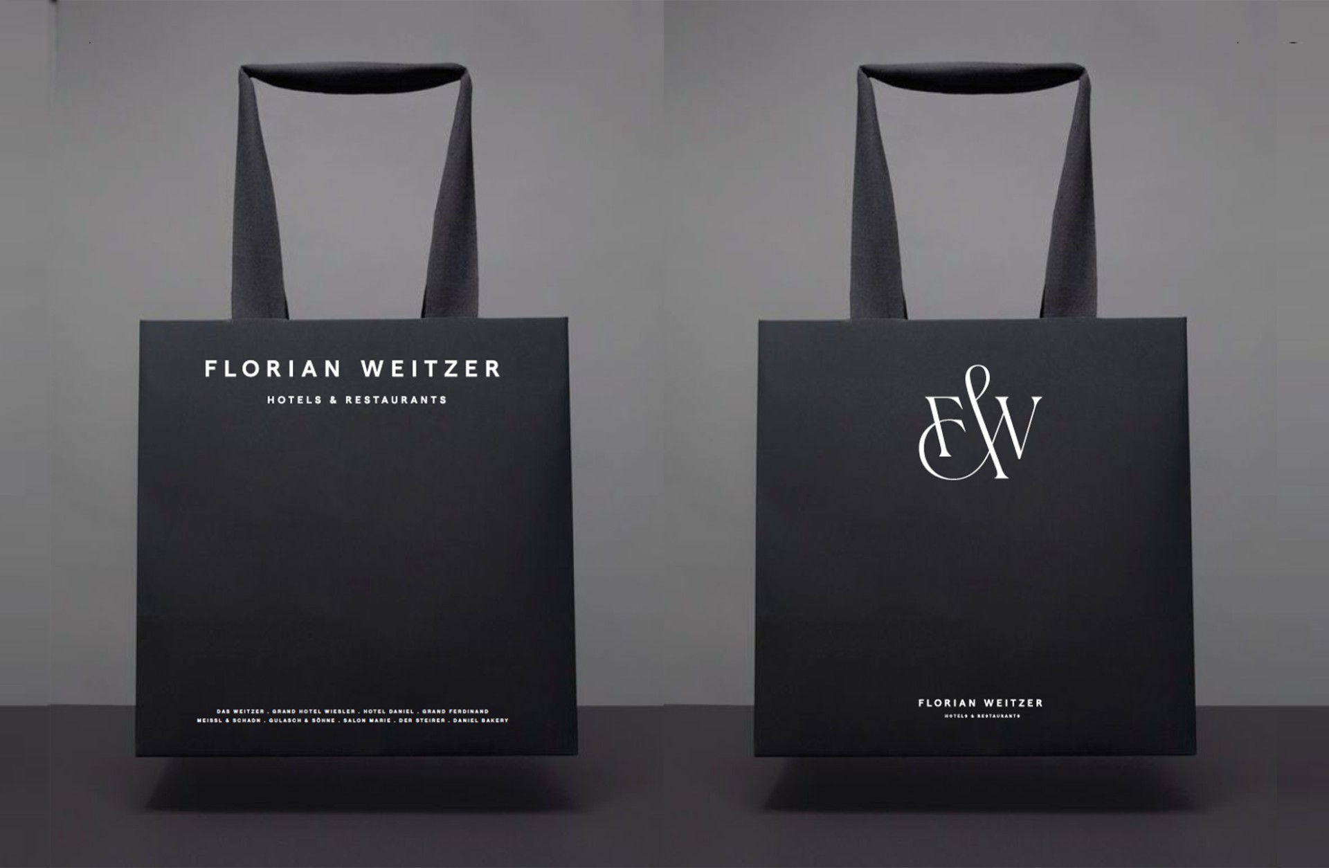 Schwarze Florian Weitzer Hotels & Restaurants-Einkaufstüten mit Griffen. Eine zeigt "FLORIAN WEITZER", die andere "FW"-Logo.