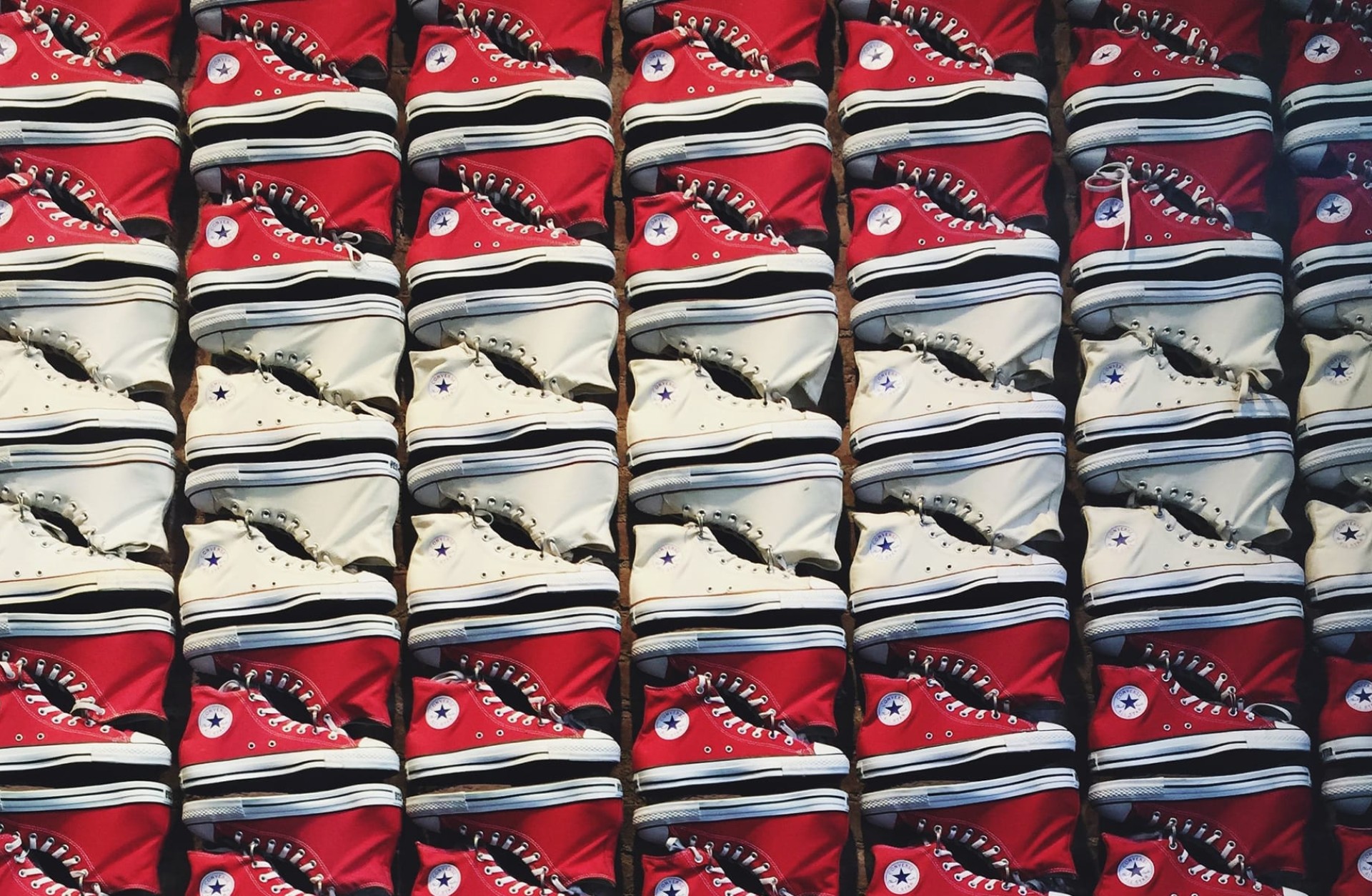Reihen von roten und weißen Converse Chuck Taylor All-Stars mit Sternlogo.