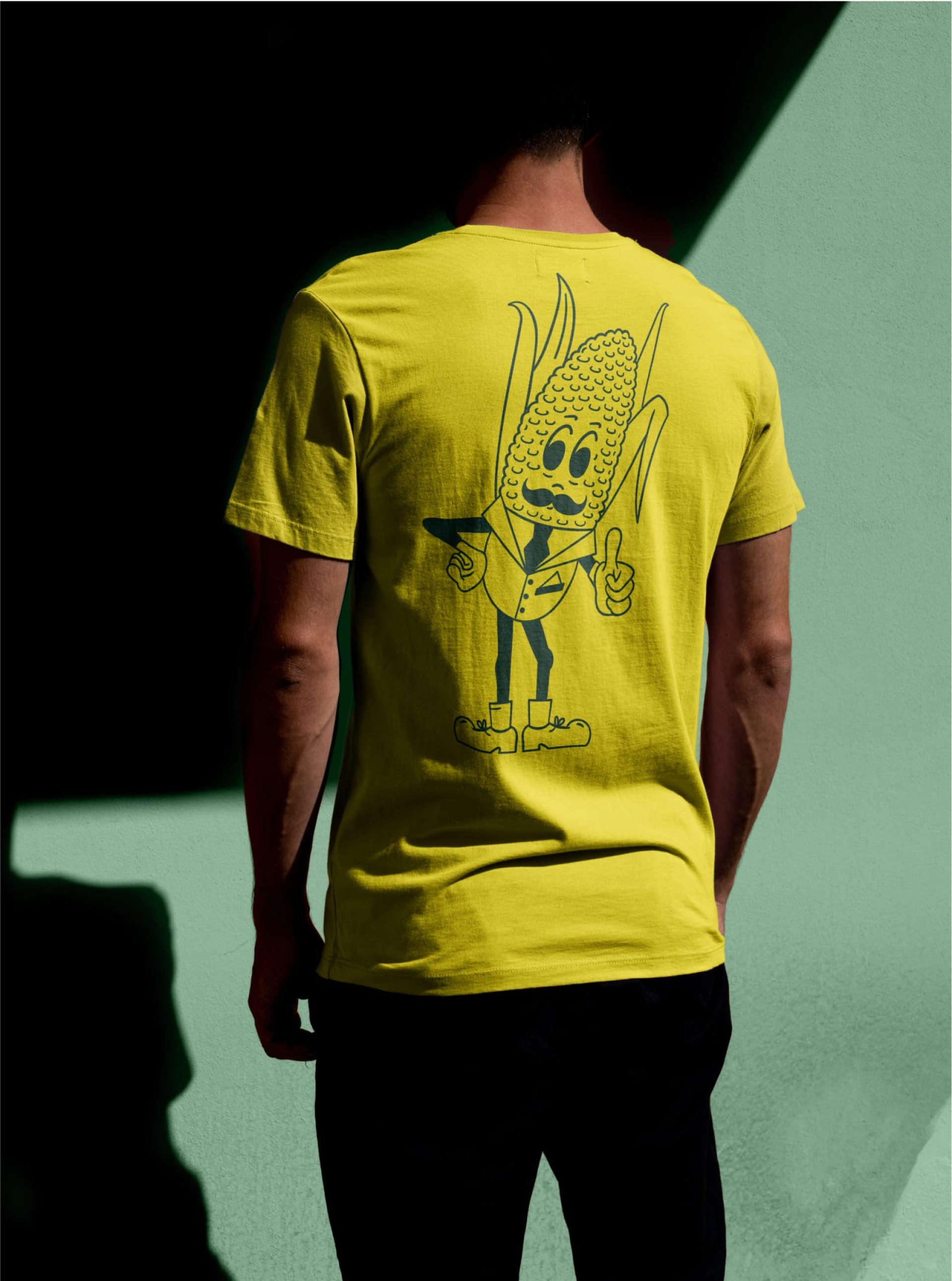 Ein Mann trägt ein gelbes T-Shirt mit einer Comic-Maisfigur, die einen Anzug trägt.