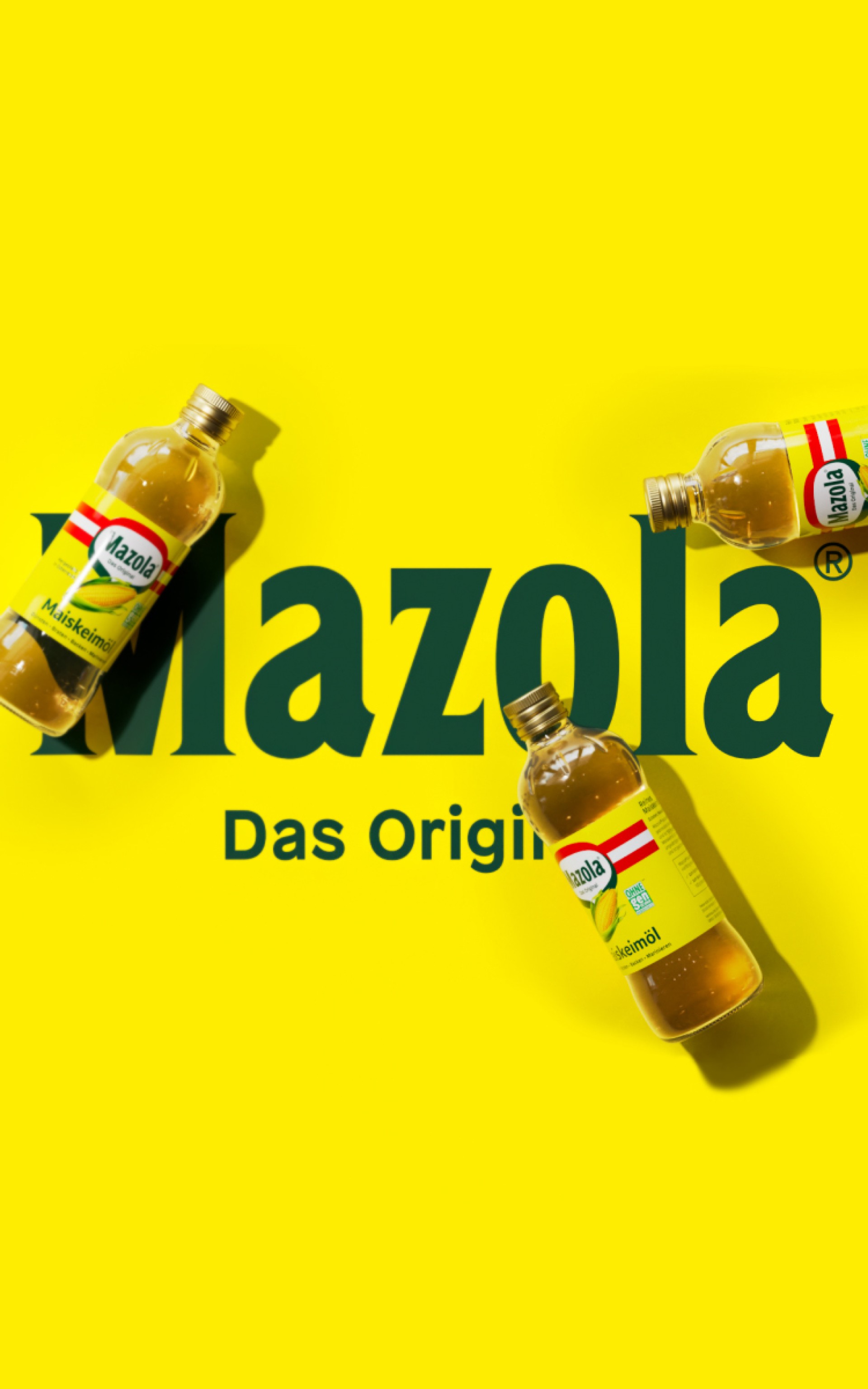 Drei Mazola-Ölflaschen auf gelbem Hintergrund mit dem Text „Mazola Das Original“.