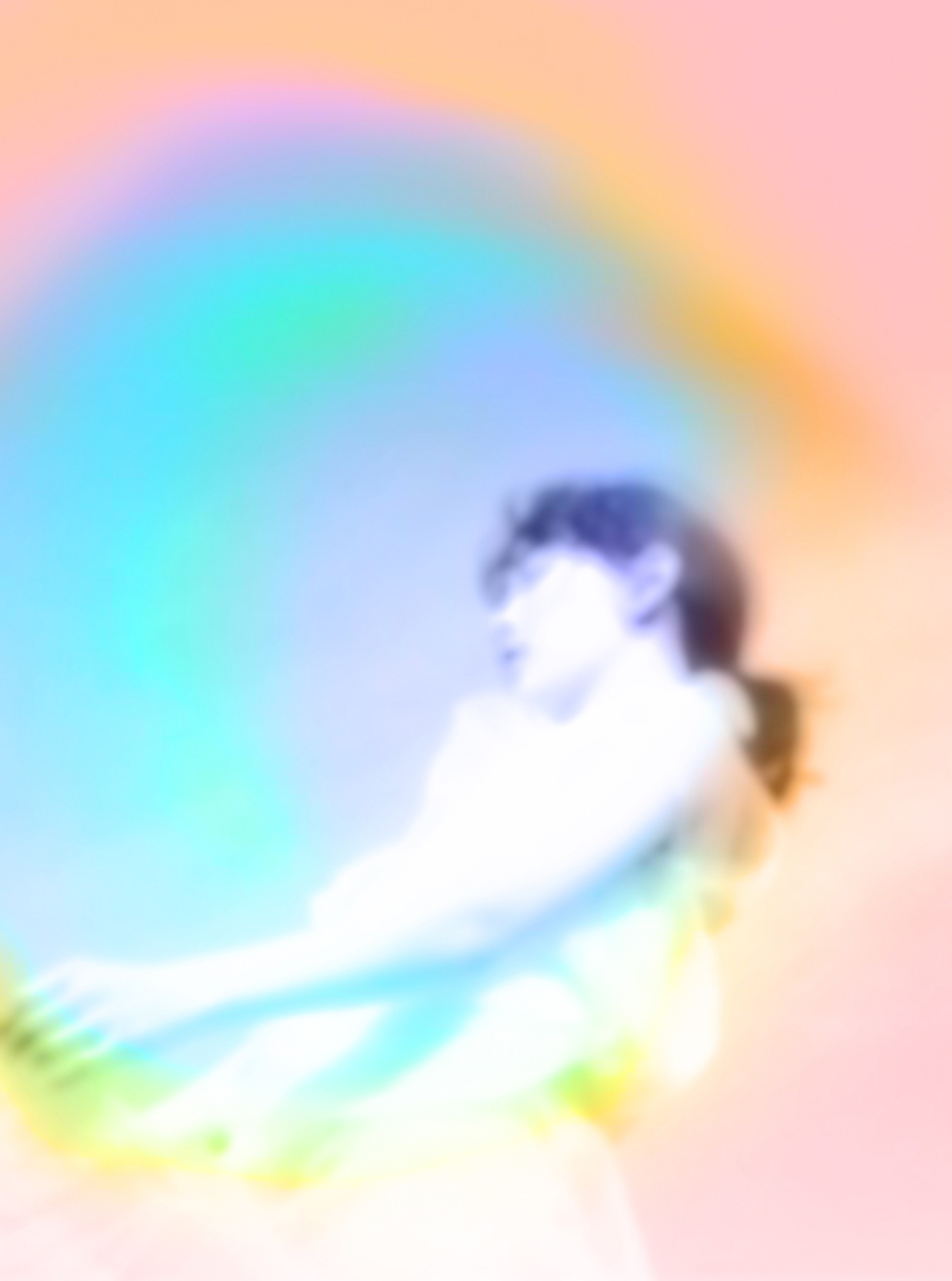 Verschwommene Nahaufnahme einer Person mit Zopf und Aura in Blau, Gelb und Rosa.