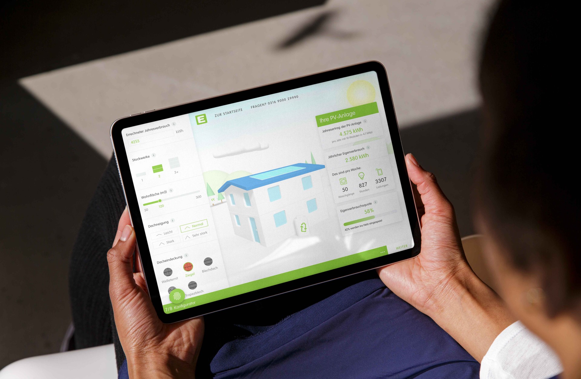 Eine Person hält ein Tablet mit einer App zur Solarenergiekonfiguration in der Hand.