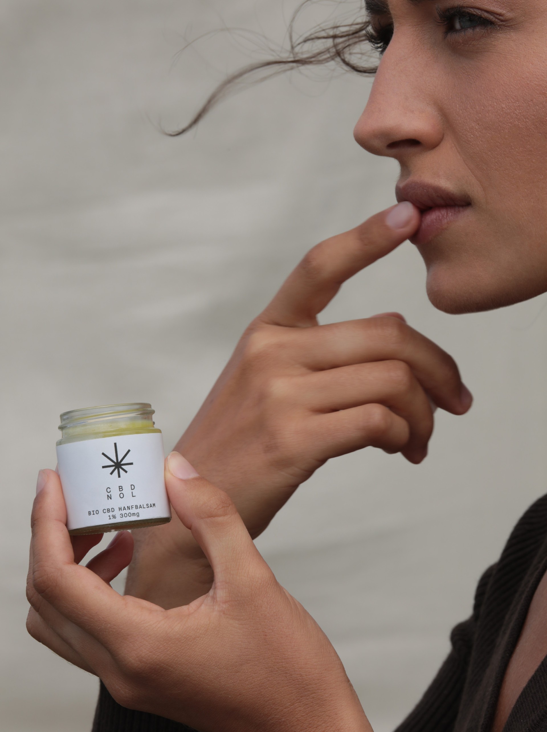 cbdnol_moodley_branding_frau_nutzt_hanfbalsam_auf_lippen