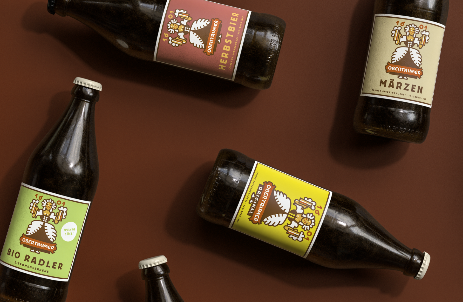 Mehrere Flaschen Obertrumer Bier: Herbstbier, Märzen, Bio Radler Zitrone. Etiketten zeigen ein Mädchen, das Bierkrüge hält.