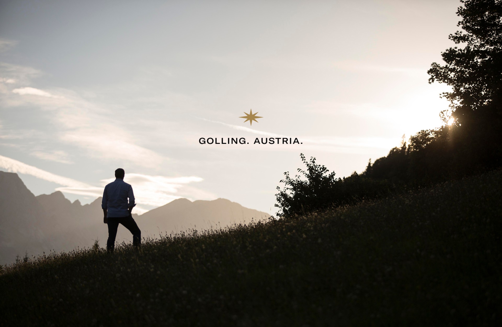 Silhouette eines Mannes in Golling, Österreich, mit Bergen und Bäumen im Hintergrund. Der Text lautet "GOLLING. AUSTRIA".