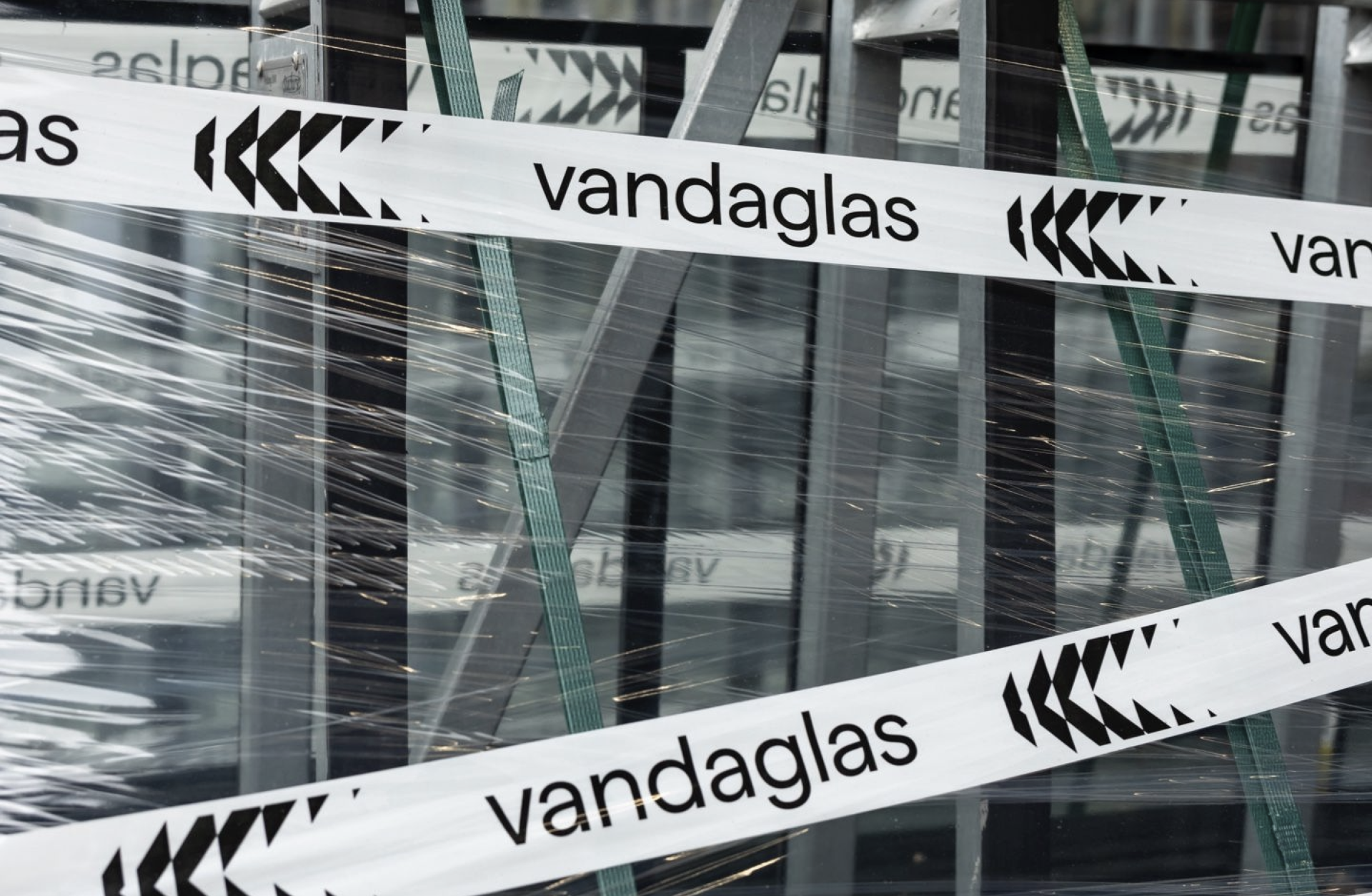 Ein Paket mit dem Namen "vandaglas" ist mit weißem Klebeband verschlossen und in Plastikfolie eingewickelt.