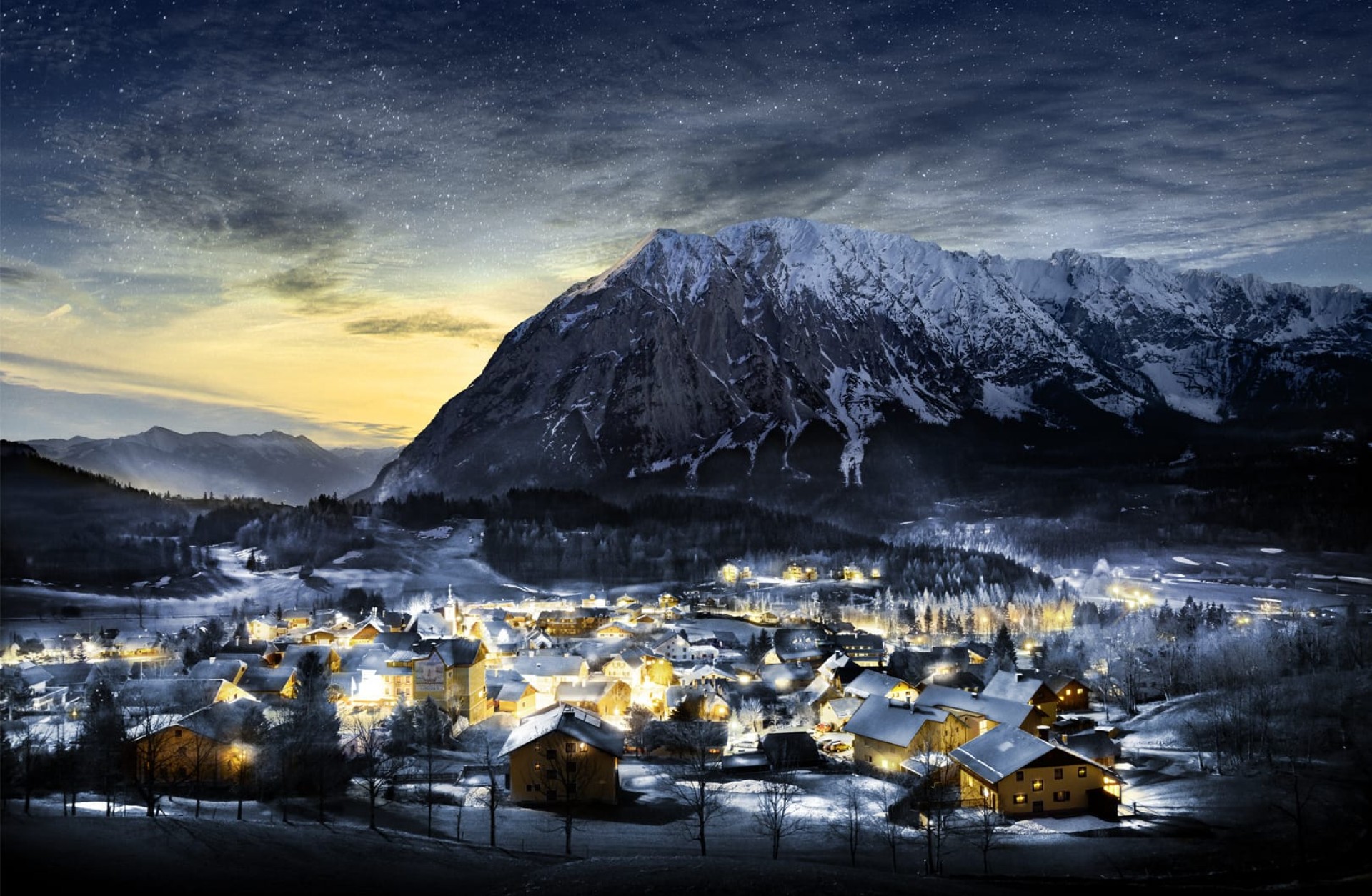 Eine Winterlandschaft mit Häusern, die mit Schnee bedeckt sind, und einem Berg im Hintergrund.