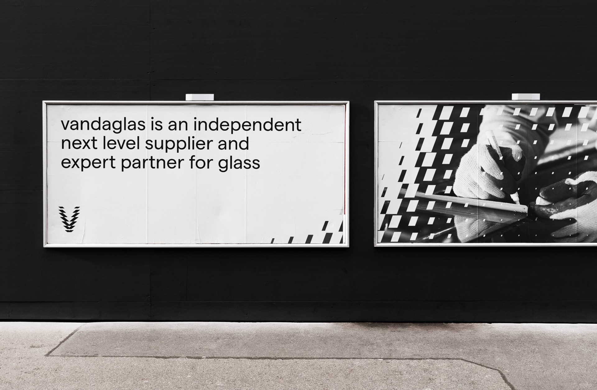 Zwei Werbetafeln an einer schwarzen Wand. Text: "vandaglas ist ein unabhängiger Next-Level-Lieferant und ein erfahrener Partner für Glas".