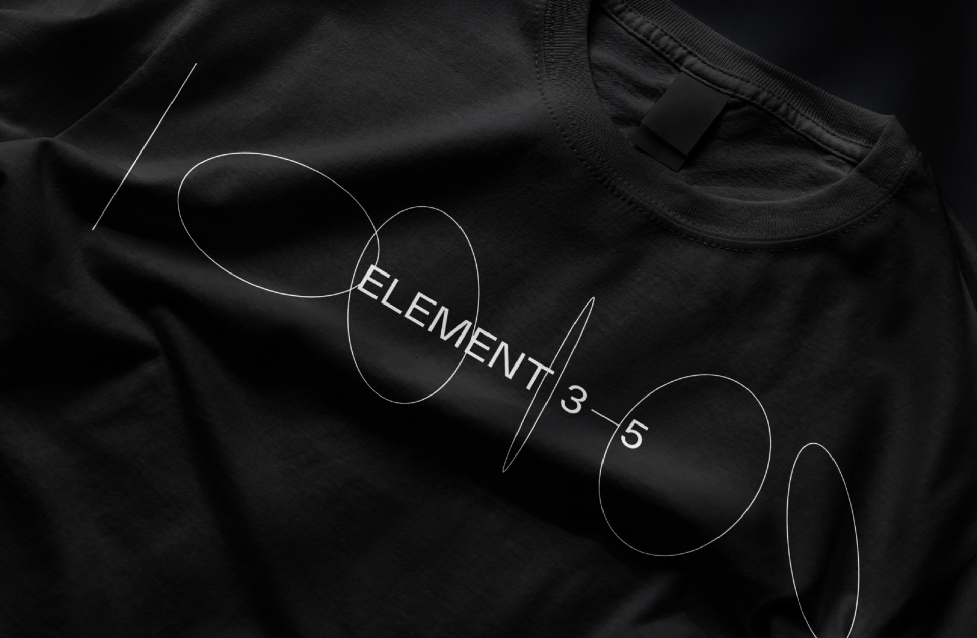 Ein schwarzes T-Shirt mit weißem Aufdruck „Element 3–5“ und sich überschneidenden Kreisen.