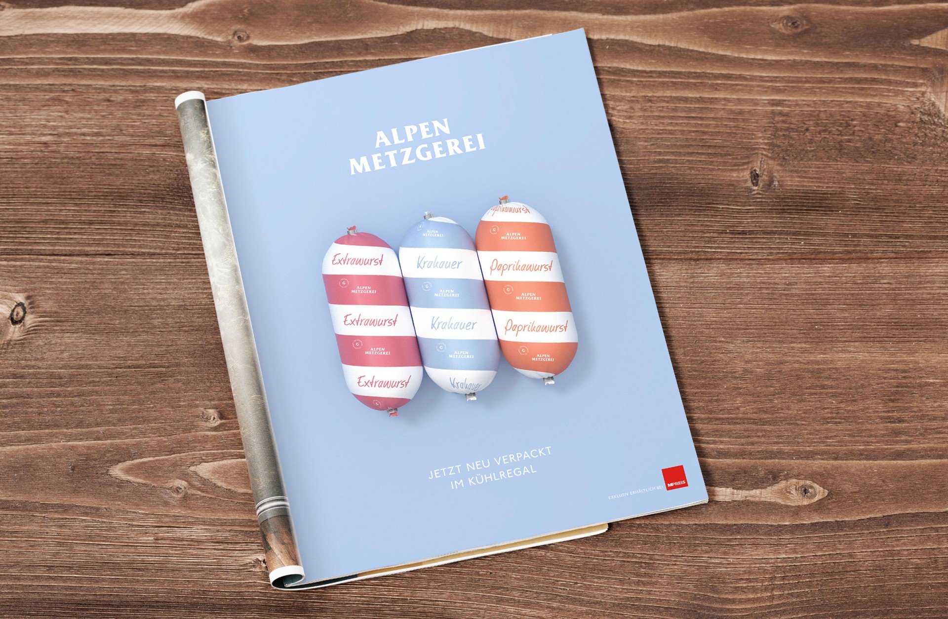 Ein Magazin von Alpen Metzgerei, das Extrawurst, Krakauer und Paprikawurst zeigt. Der Text lautet "Jetzt neu verpackt im Kühlregal".
