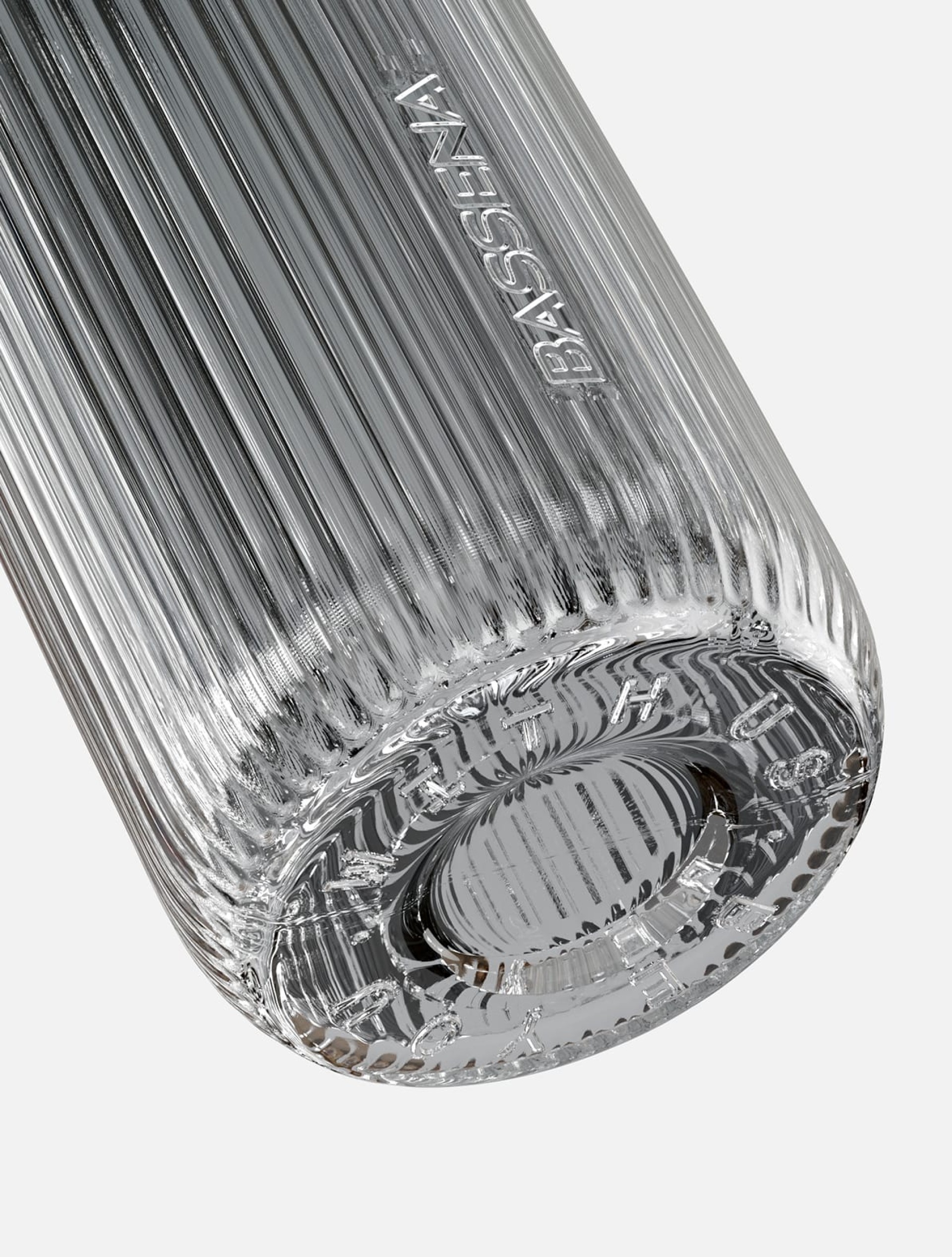 Nahaufnahme der strukturierten Glasflasche von Bassena. Text eingeschrieben.